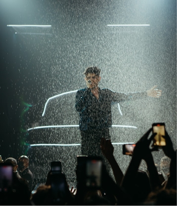 Jão cantando no palco com chuva